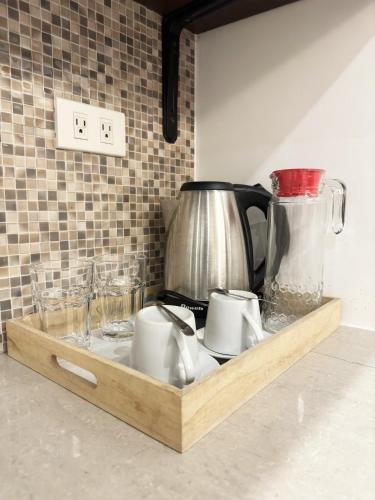 a tray with cups and a coffee pot and glasses at Nest Fort BGC in Manila