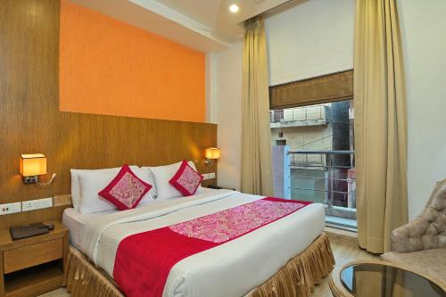 Cette chambre comprend un grand lit et une fenêtre. dans l'établissement Hotel Hari Piorko - New Delhi Railway Station, à New Delhi