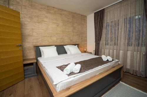 a bedroom with a large bed with white pillows at Casa DaFin Tekija - Kladovo in Tekija