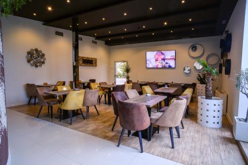 Hotel Crystal Light في نيشْ: مطعم فيه طاولات وكراسي في الغرفة