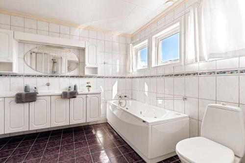 y baño con bañera, aseo y lavamanos. en Large home in Sola, en Tananger