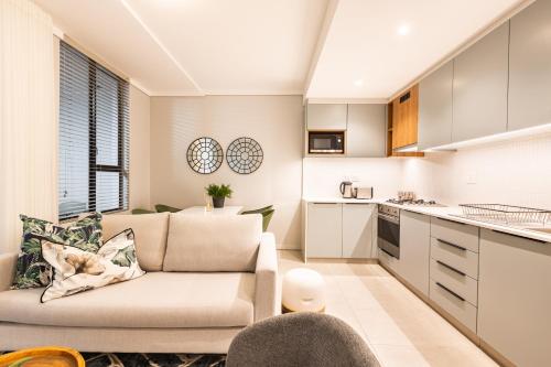 a living room with a couch and a kitchen at The Tyne Luxury Apartments in Durban