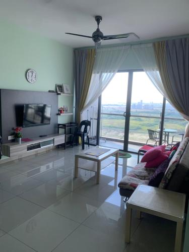 a living room with a couch and a large window at ATLANTIS@MELAKA BY SWEETSTAY in Melaka