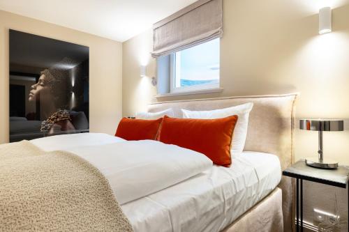um quarto com uma grande cama branca com almofadas laranja em NEU! Ferienwohnung Kuestenchalet in Keitum auf Sylt em Keitum