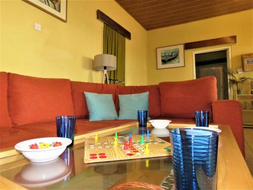 a living room with a couch and a table at Rent your own private beach bungalow in Ampeni