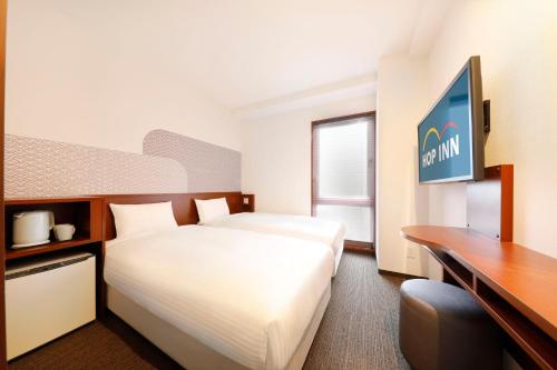 京都市にあるHop Inn Kyoto Shijo Omiyaのベッドとデスクが備わるホテルルームです。