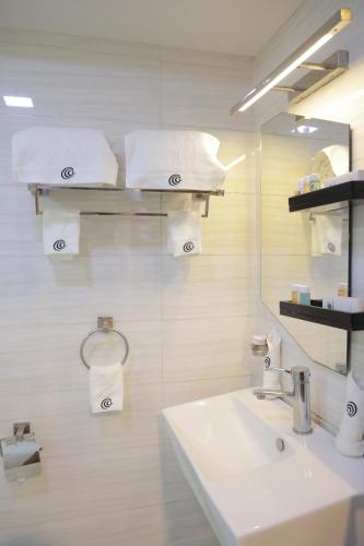 a bathroom with a sink and a mirror and towels at Ambassador Hotel in Addis Ababa