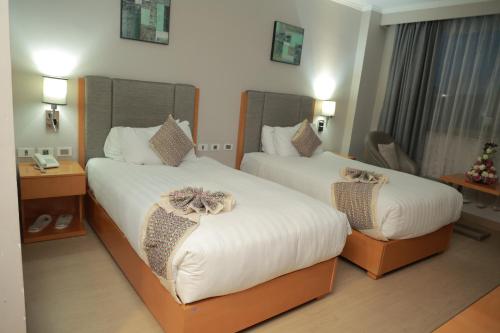 a hotel room with two beds with bows on them at Ambassador Hotel in Addis Ababa