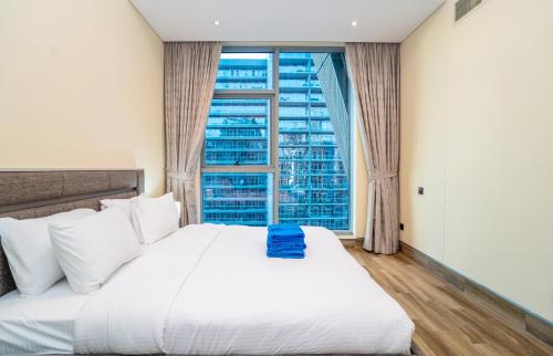 a bedroom with a white bed with a large window at New Arabian 2 Bedroom J One Tower Business Bay in Dubai