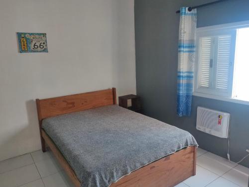 um quarto com uma cama e uma janela em Moradas Vô Ary em Garopaba