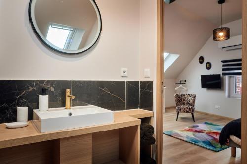 Le Vaudreuil的住宿－LE CLOS 1899，一间带水槽和镜子的浴室