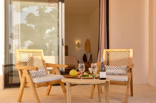 two chairs and a table with wine glasses on it at Kawga Hôtel in Ngaring