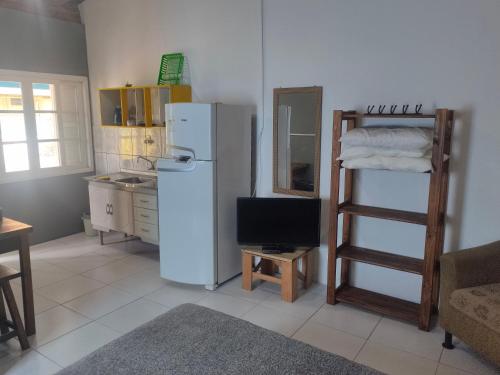 a kitchen with a white refrigerator and a ladder at Moradas Vô Ary in Garopaba