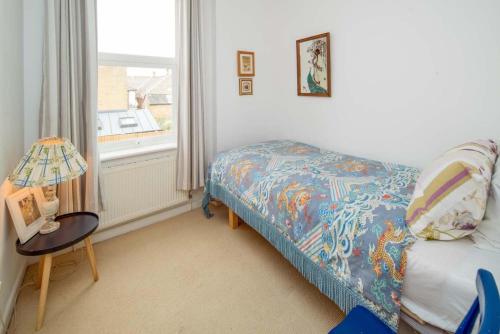 a bedroom with a bed and a table and a window at Flat 1, Medeira House in Seaview