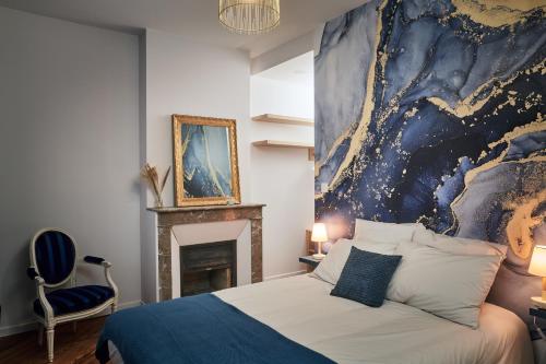 Le Vaudreuil的住宿－LE CLOS 1899，卧室配有一张床,墙上挂有绘画作品