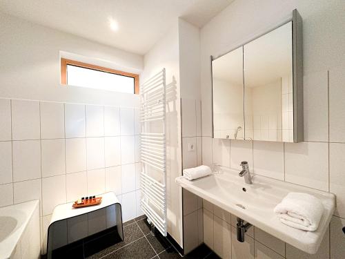 a white bathroom with a sink and a mirror at Chalet Oberstaufen in Oberstaufen