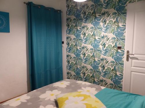 1 dormitorio con 1 cama y papel pintado con motivos florales en Chez Marie, en Carry-le-Rouet