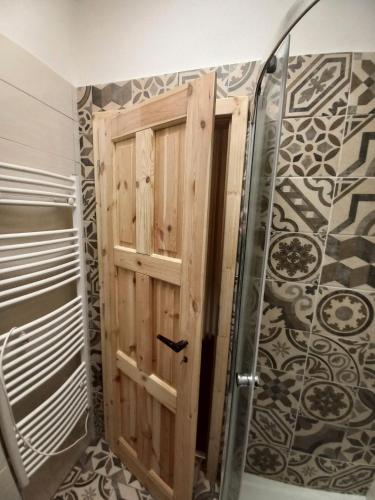 a shower with a wooden door in a bathroom at Villa Oliva in Český Krumlov