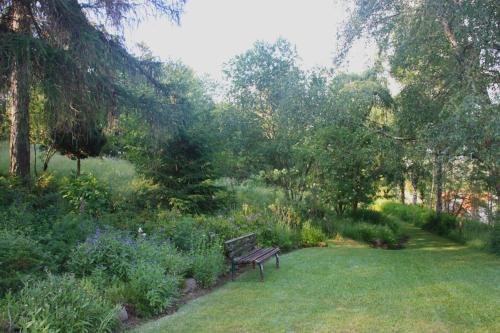 a park bench sitting in the middle of a garden at Harzhaus Drei Hexen in Tanne