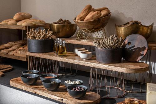 a shelf filled with lots of bowls and bread at Indigo Inn Casa Adults Only in Hersonissos