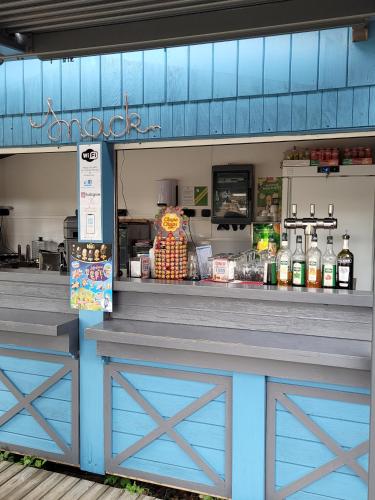 a store front with a blue counter with a food at Camping Le Soulhol in Saint-Céré