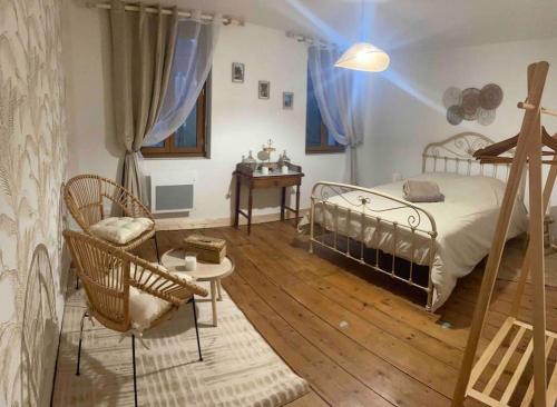 um quarto com uma cama, uma cadeira e uma mesa em Gîte « Le Querqus » - 6 voyageurs em Allouville-Bellefosse