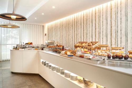 un comptoir de boulangerie avec beaucoup de nourriture en exposition dans l'établissement Junior Family Hotel, à Cavallino-Treporti