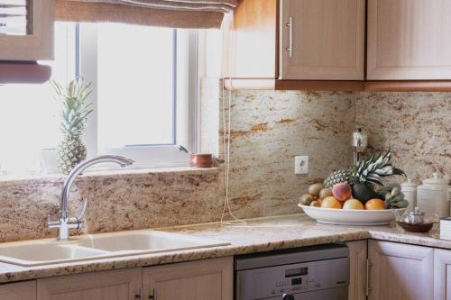 uma cozinha com um lavatório e uma taça de fruta em Selenophile Villa em Monolithos
