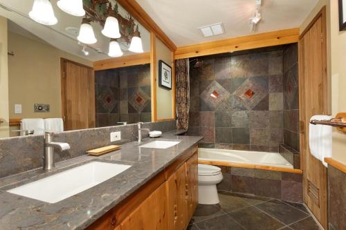 a bathroom with a tub and a sink and a toilet at Hearthstone Lodge 3 - Central Village Condo with Private Sauna & Hot Tub - Whistler Platinum in Whistler