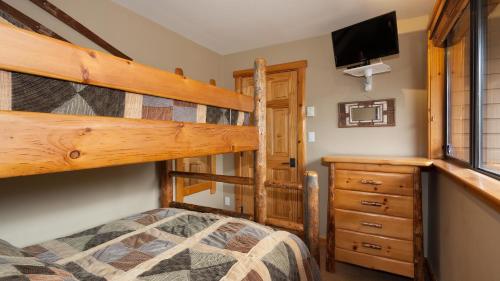 a bedroom with a bunk bed and a tv at Hearthstone Lodge 3 - Central Village Condo with Private Sauna & Hot Tub - Whistler Platinum in Whistler