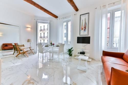 un salon blanc avec une table et un canapé dans l'établissement Alba apartment antibes street, by Welcome to Cannes, à Cannes