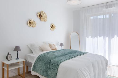 une chambre blanche avec un lit et une fenêtre dans l'établissement Résidence de Bourges, à Bourges