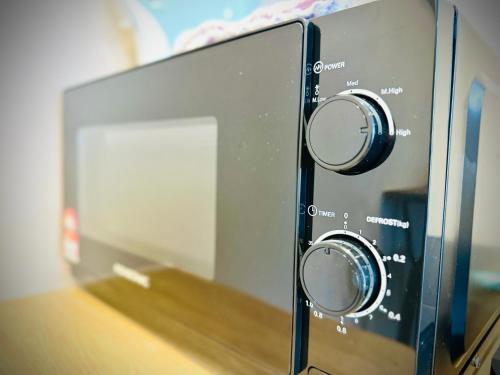 a microwave oven with two knobs on a counter at New 2BR or 3BR Cozy Urban Suite Homestay at Georgetown8-10pax by URBAN STAYCATIONS LOD in Jelutong