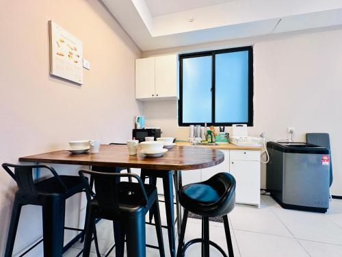 a kitchen with a wooden table and black chairs at New 2BR or 3BR Cozy Urban Suite Homestay at Georgetown8-10pax by URBAN STAYCATIONS LOD in Jelutong
