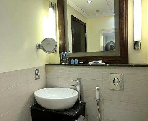 a bathroom with a sink and a mirror at Sofitel Al Khobar The Corniche in Al Khobar