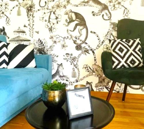 a living room with a blue couch and a table at Fly Inn Apartment Berlin in Schönefeld