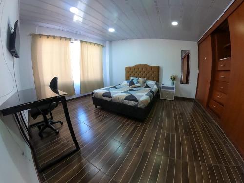 1 dormitorio con 1 cama y escritorio en una habitación en Casa Tranquila en Bogotá