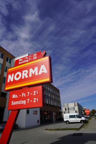 a sign for a nomma store in a parking lot at Fly Inn Apartment Berlin in Schönefeld