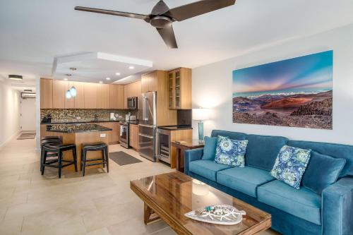 uma sala de estar com um sofá azul e uma cozinha em Kamaole Sands 1-307 - Stunning Renovation, New AC! em Wailea