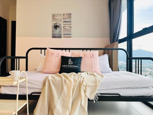 a bedroom with a bed with pink and white pillows at New 2BR or 3BR Cozy Urban Suite Homestay at Georgetown8-10pax by URBAN STAYCATIONS LOD in Jelutong