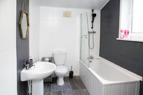 a bathroom with a sink and a toilet and a bath tub at Stylish and Spacious 3-Bed House in Barrow-in-Furness with Free WiFi by Amazing Spaces Relocations Ltd in Barrow in Furness