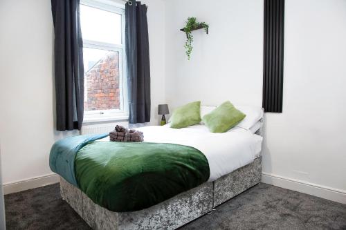a bedroom with a large bed with a window at Stylish and Spacious 3-Bed House in Barrow-in-Furness with Free WiFi by Amazing Spaces Relocations Ltd in Barrow in Furness