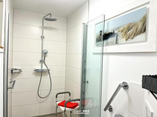łazienka z prysznicem i czerwonym stołkiem w obiekcie villa kunterBUNT w mieście Grödersby