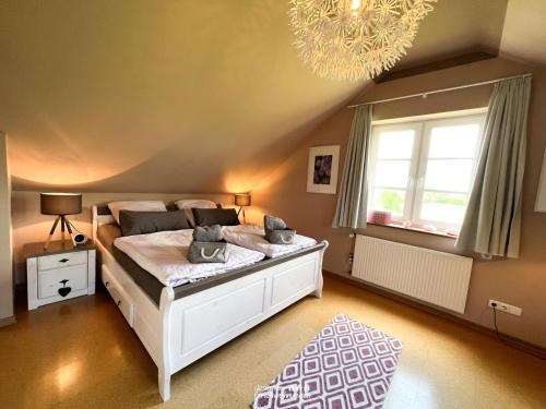 sypialnia z łóżkiem i żyrandolem w obiekcie villa kunterBUNT w mieście Grödersby