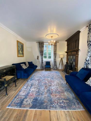 - un salon avec des canapés bleus et un tapis dans l'établissement Brittany Carantec Morlaix, à Saint-Martin-des-Champs
