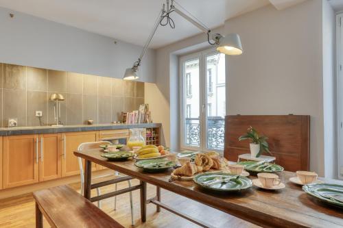 - une cuisine avec une table en bois et de la nourriture dans l'établissement Spacious & lovely flat-Up to 10 guests-Paris 10, à Paris