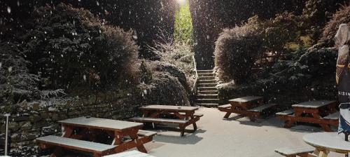 un grupo de mesas de picnic en la nieve en The Herdwick Inn, en Penruddock