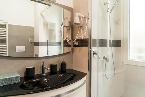 een badkamer met een wastafel en een douche met een spiegel bij Roma San Pietro - Le Grazie del Vaticano in Rome
