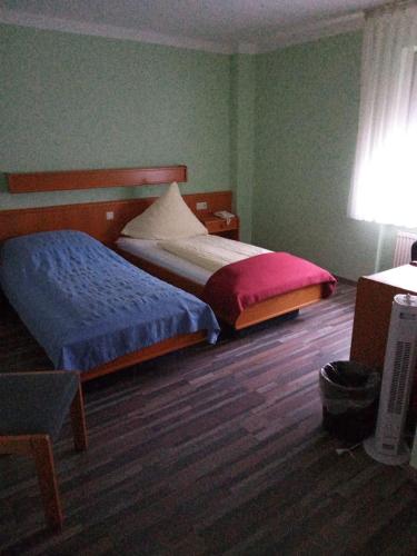 フランクフルト・アム・マインにあるHausener Dorfkrugのベッドルーム1室(ベッド2台、デスク、ランプ付)