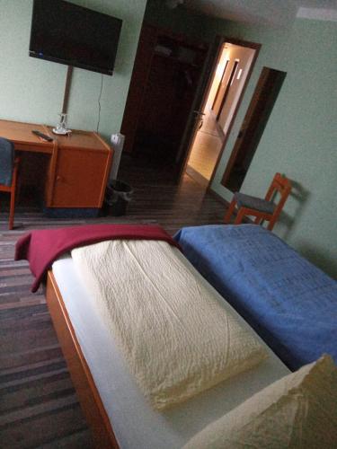 フランクフルト・アム・マインにあるHausener Dorfkrugのベッドルーム(ベッド1台、デスク、テレビ付)